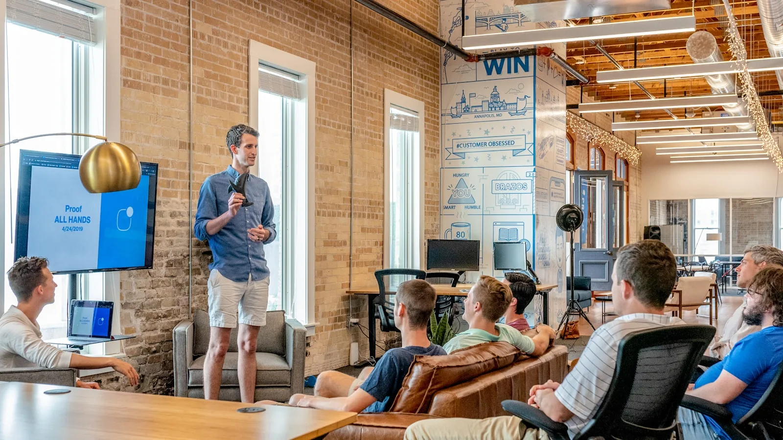 A leader presenting to a seated team in a modern office