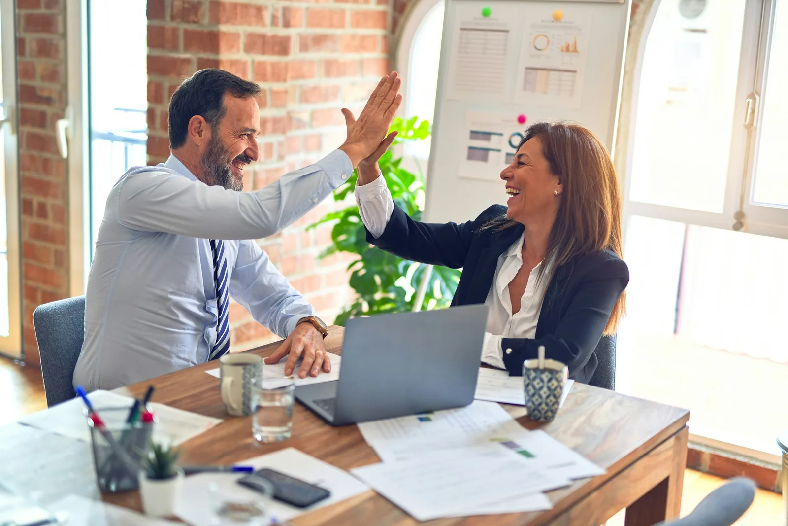 Two professionals reviewing strategy at a table, representing private equity operating partners evaluating portfolio-company execution