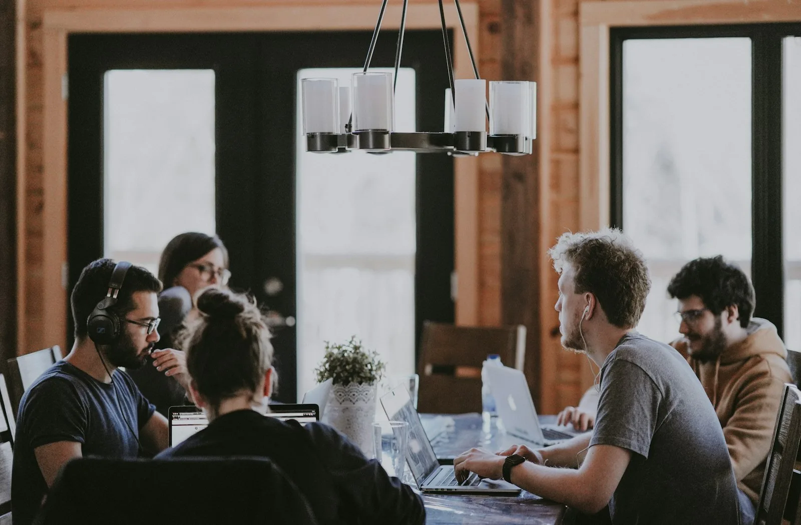 A cybersecurity team collaborating on laptops around a table