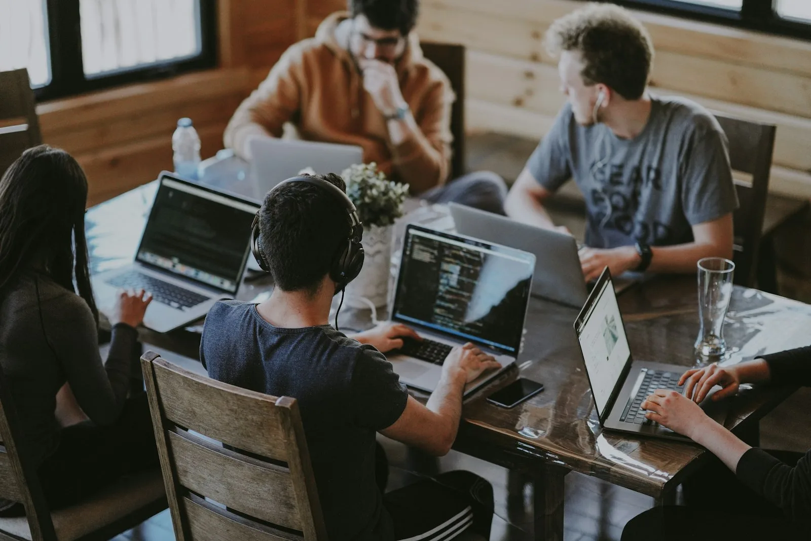 A diverse team working together on laptops at a shared table
