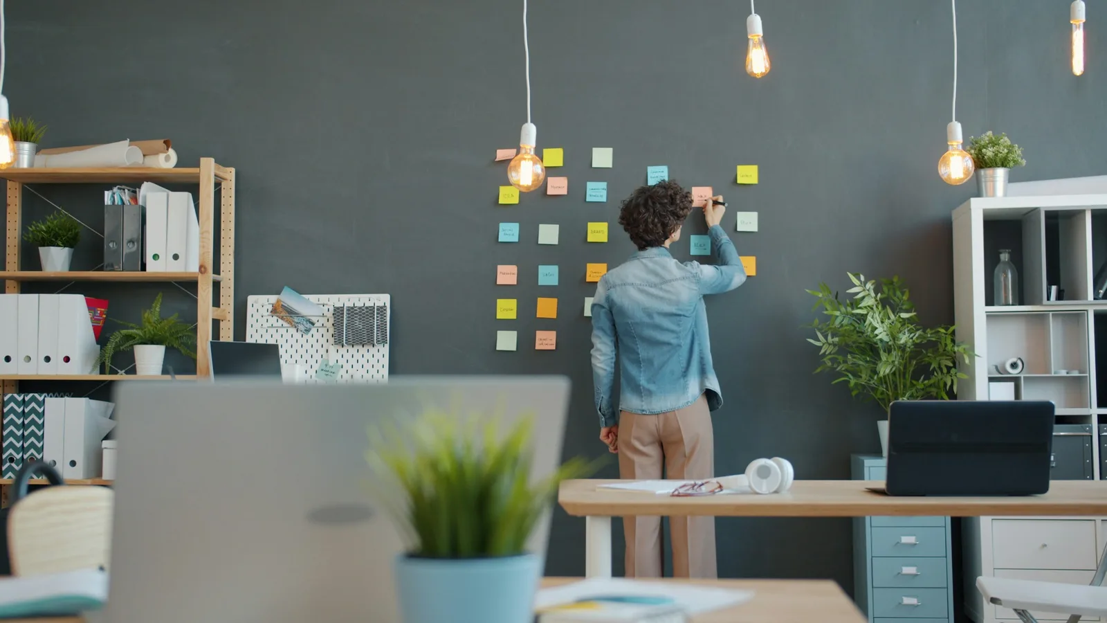 A professional arranging notes on a wall to lay out the work an organization actually performs